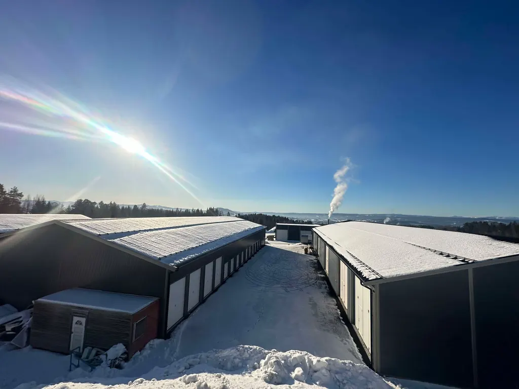 Snødekte lagerbygg med garasjeporter en klar vinterdag