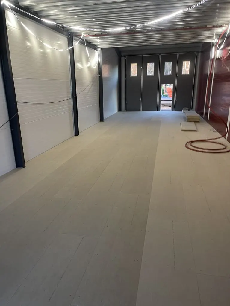 Lang, opplyst lagerhall med betonggulv